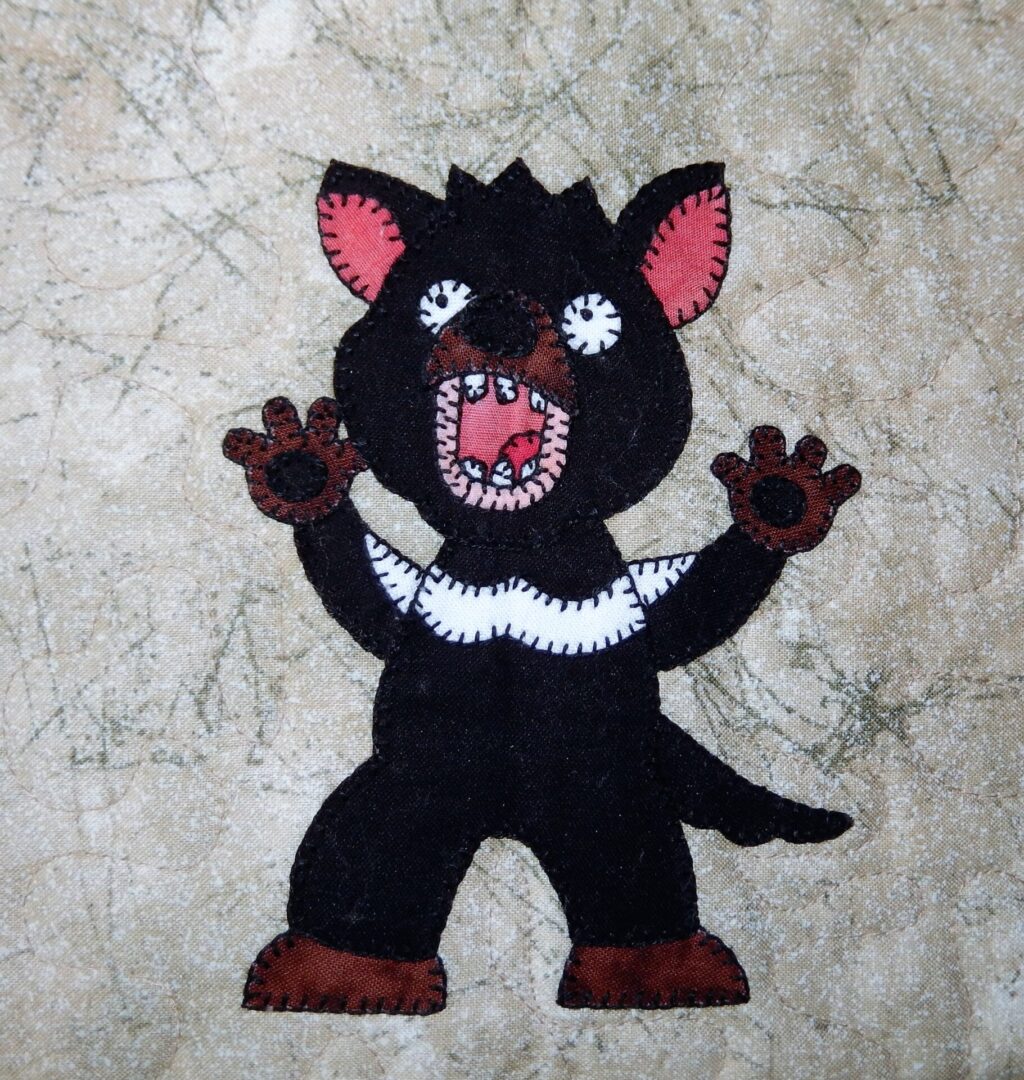 A black Tasmanian Devil with its mouth open.