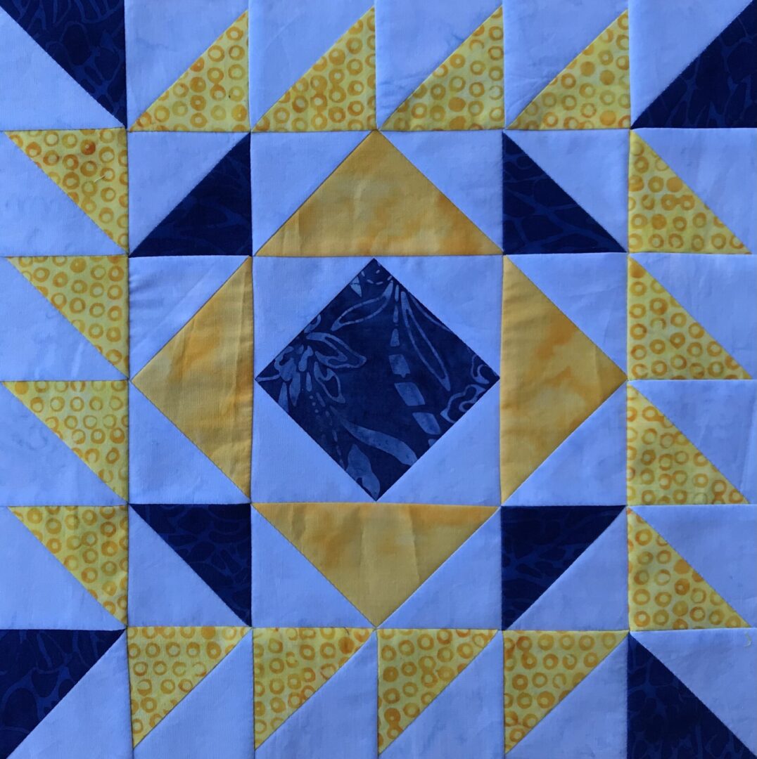 A Thunder and Lightning quilt block with yellow and blue squares.