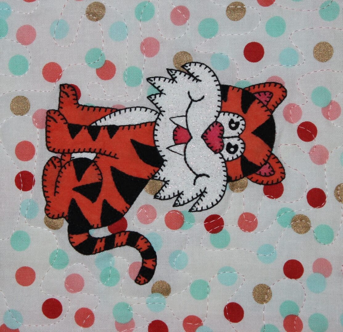 A Tiger applique on a polka dot background.