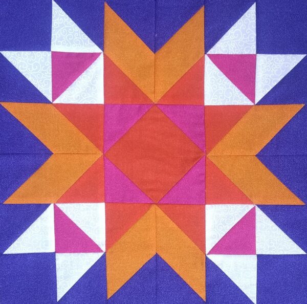 A Wyoming Valley Star quilt block with orange and purple squares.