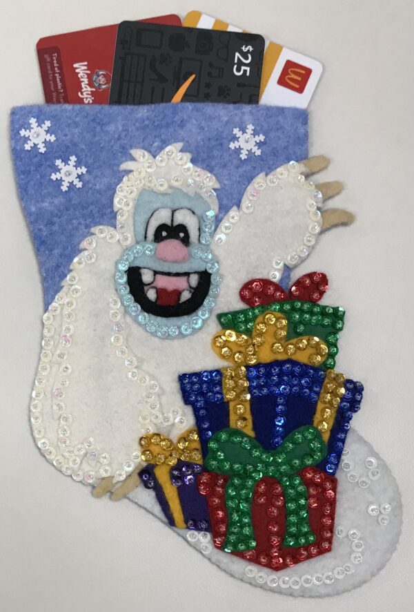 A Christmas stocking with a Yeti Gift Card Holder holding credit cards.