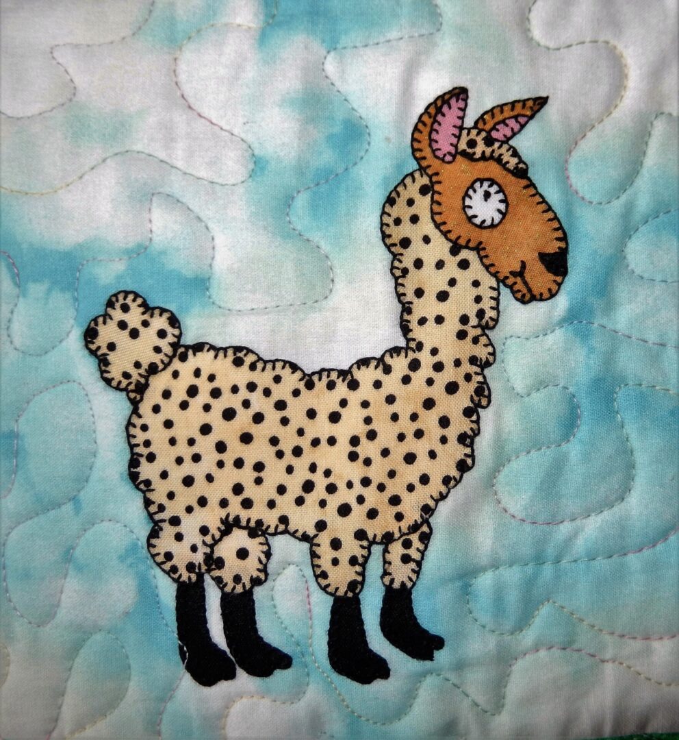 An alpaca quilted on a blue background.