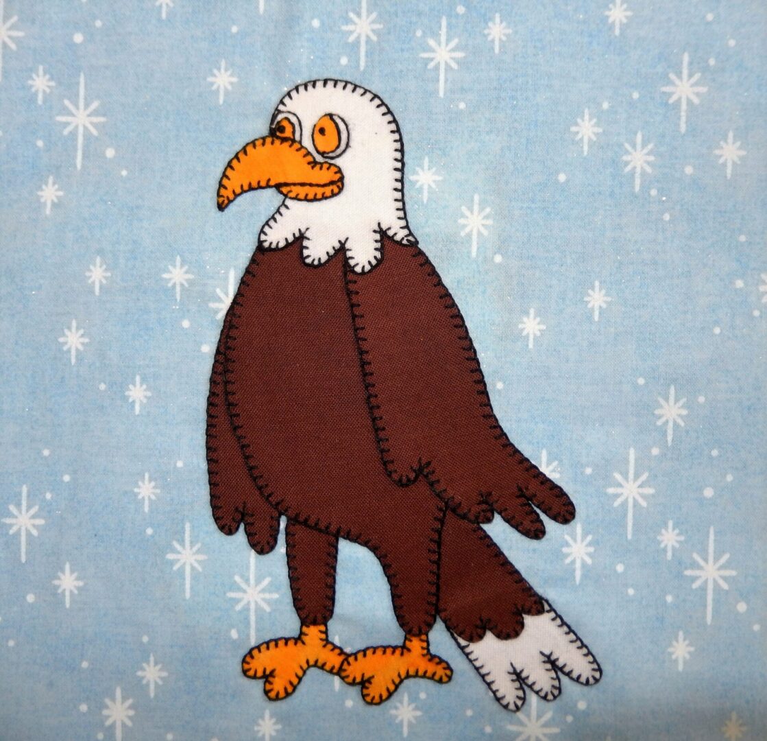 A Bald Eagle applique on a blue background.