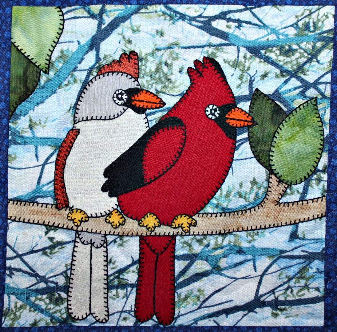 Two Cardinals sitting on a branch.