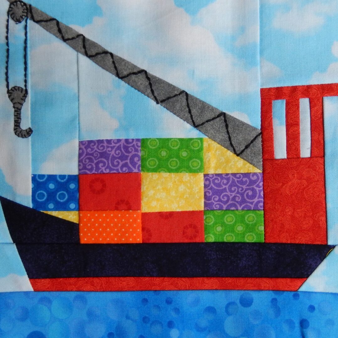 A quilt block with a cargo ship on it.
