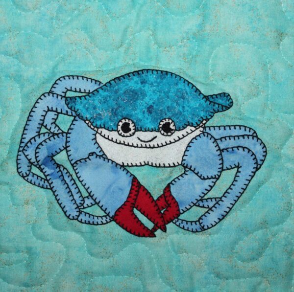 A Crab is embroidered on a blue background.