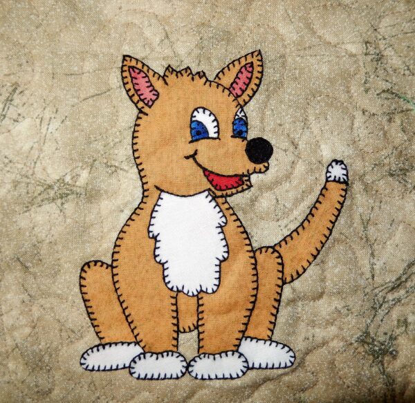 A Dingo is embroidered on a piece of fabric.