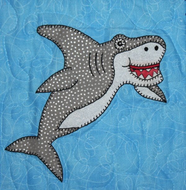 A Great White Shark appliqued on a blue background.