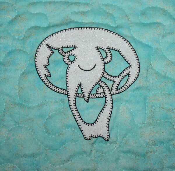 A white jellyfish on a blue quilt.