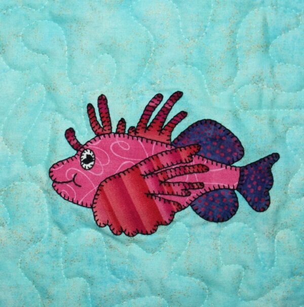 A pink and purple Lionfish appliqued on a blue background.