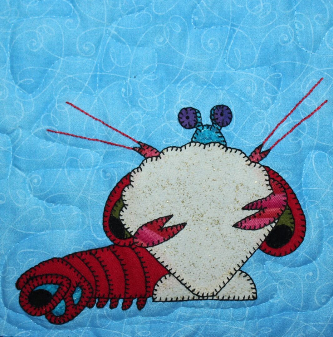 A heart shaped quilt with a mantis shrimp on it.