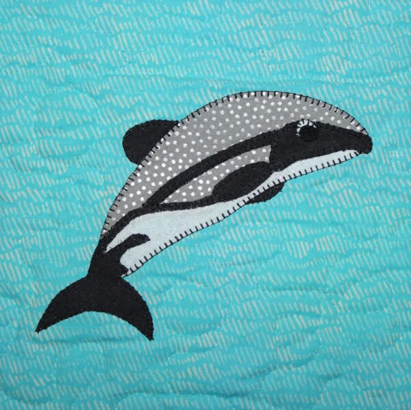 A quilt with a Maui Dolphin on it.