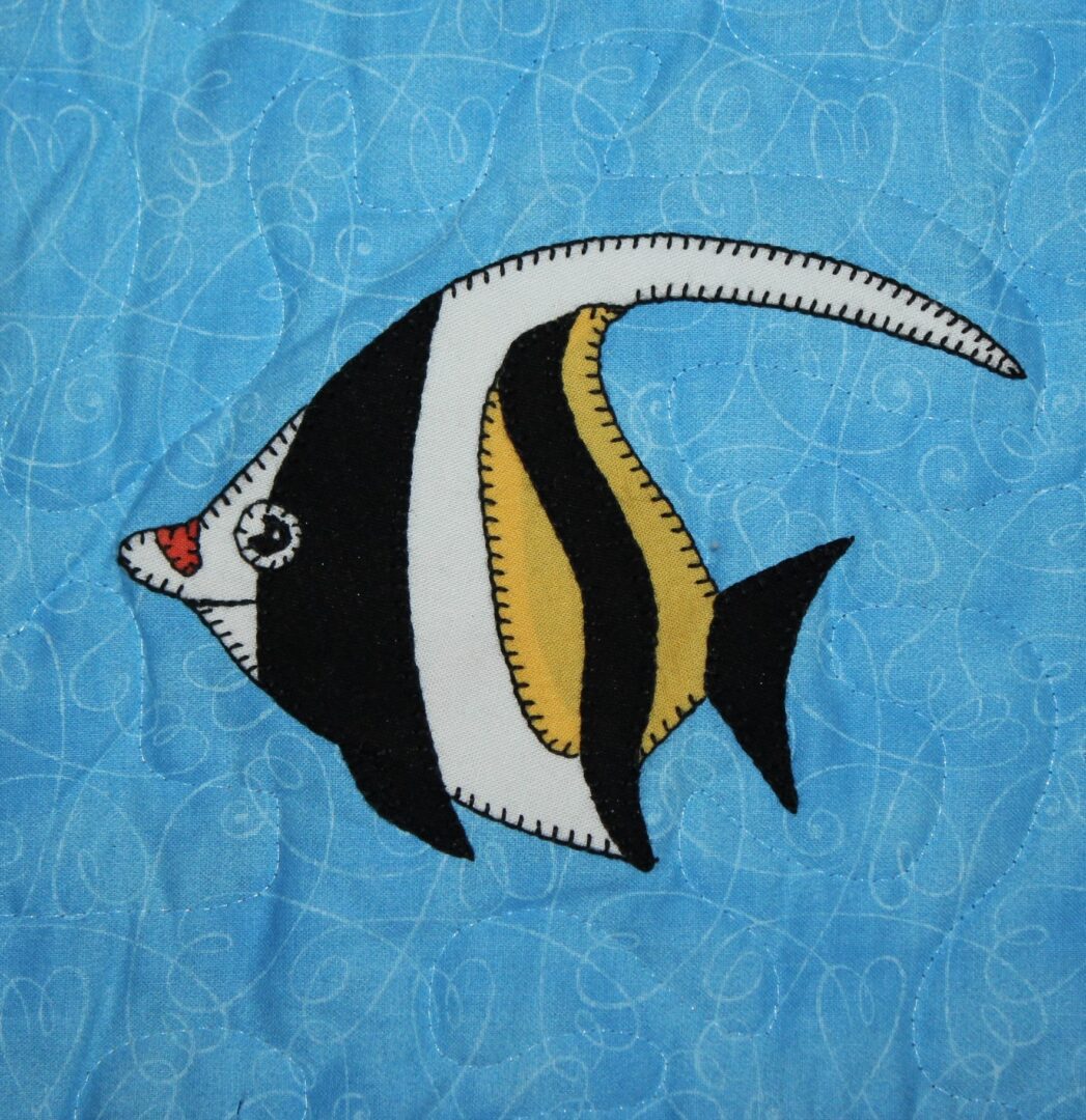 A Moorish Idol appliqued on a blue background.