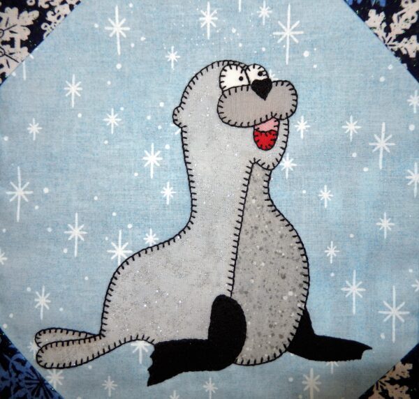 A stuffed sea lion with snowflakes on it.