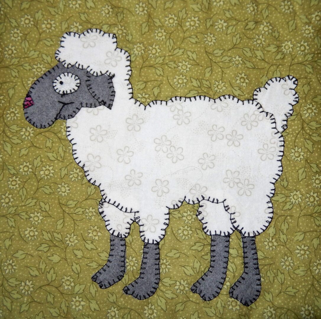 A Sheep sheep appliqued on a green background.