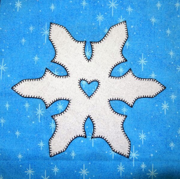 A Snowflake applique on a blue background.