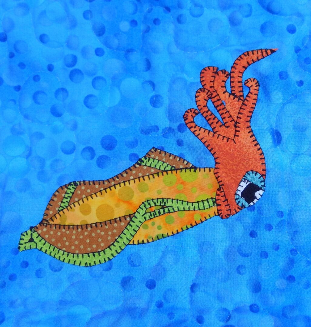 A Squid appliqued on a blue background.