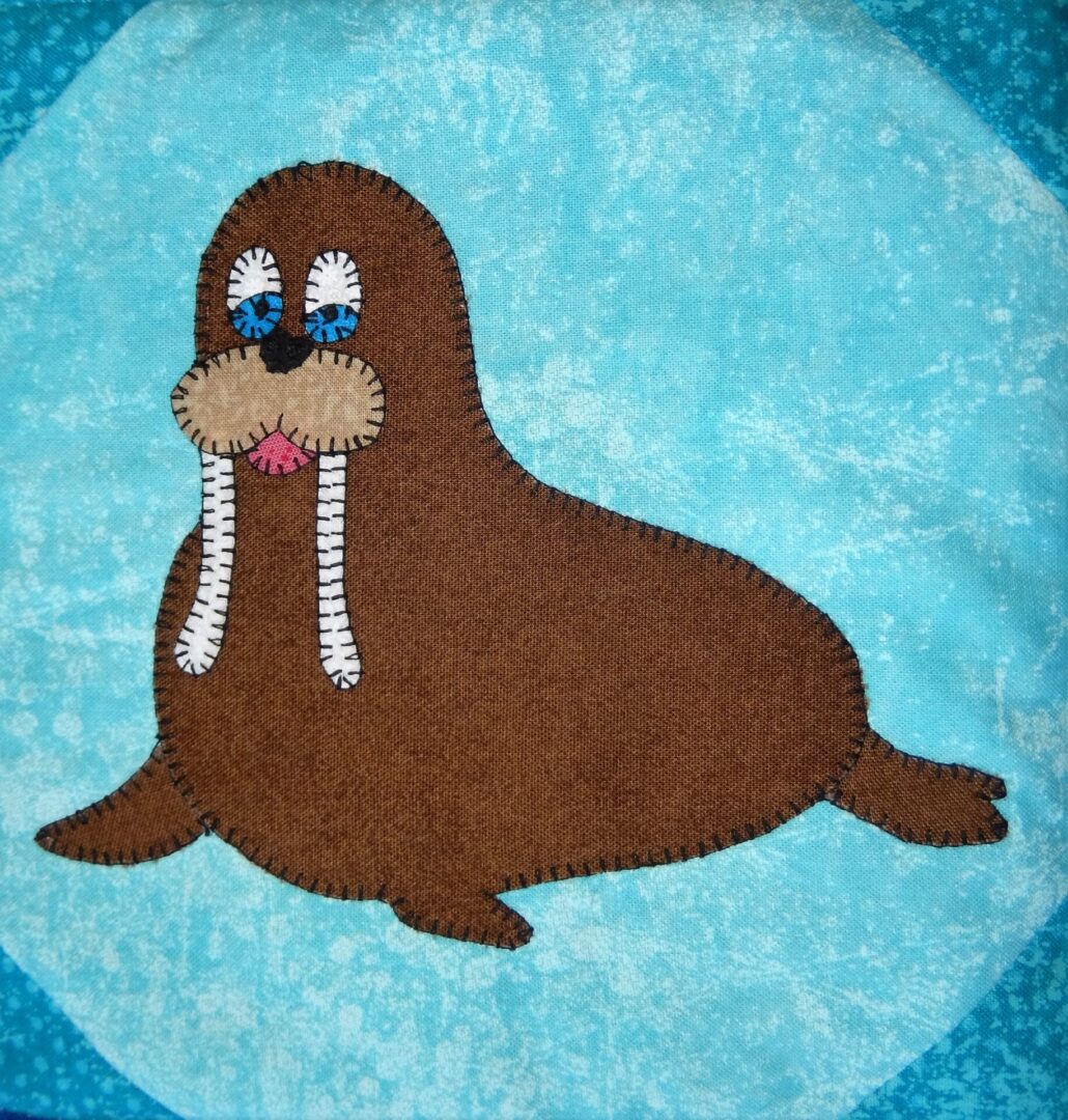 A Walrus appliqued on a blue background.